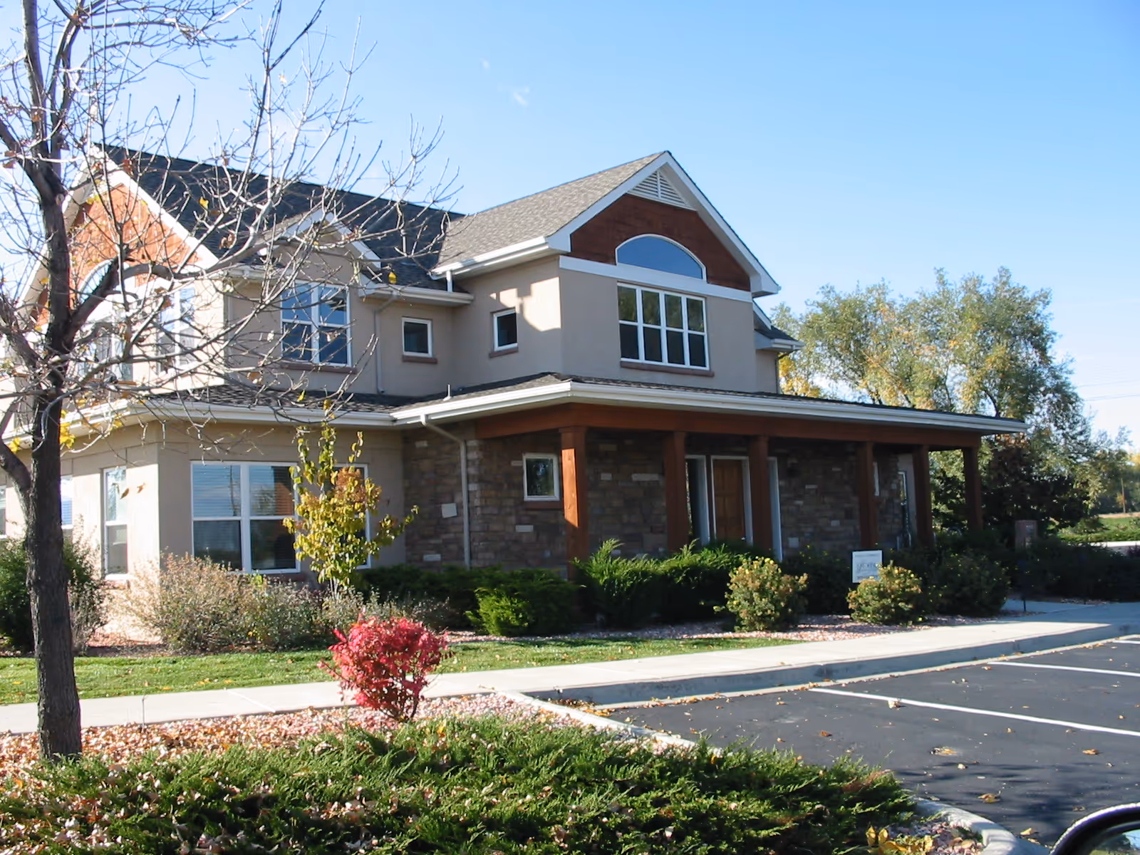 Exterior view of Family Tree Private Care senior living facility, with stone facade and landscaped yard.