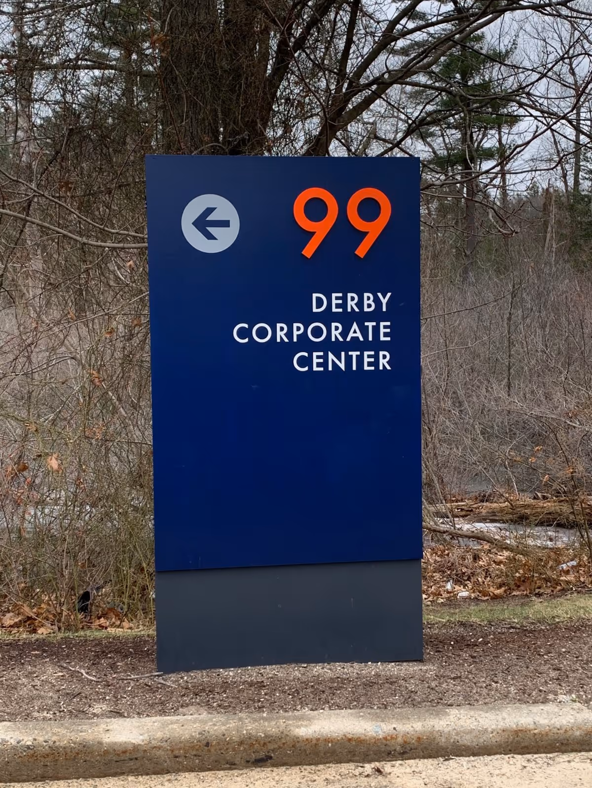 A tall blue sign reads Derby Corporate Center with the number 99 outdoors.
