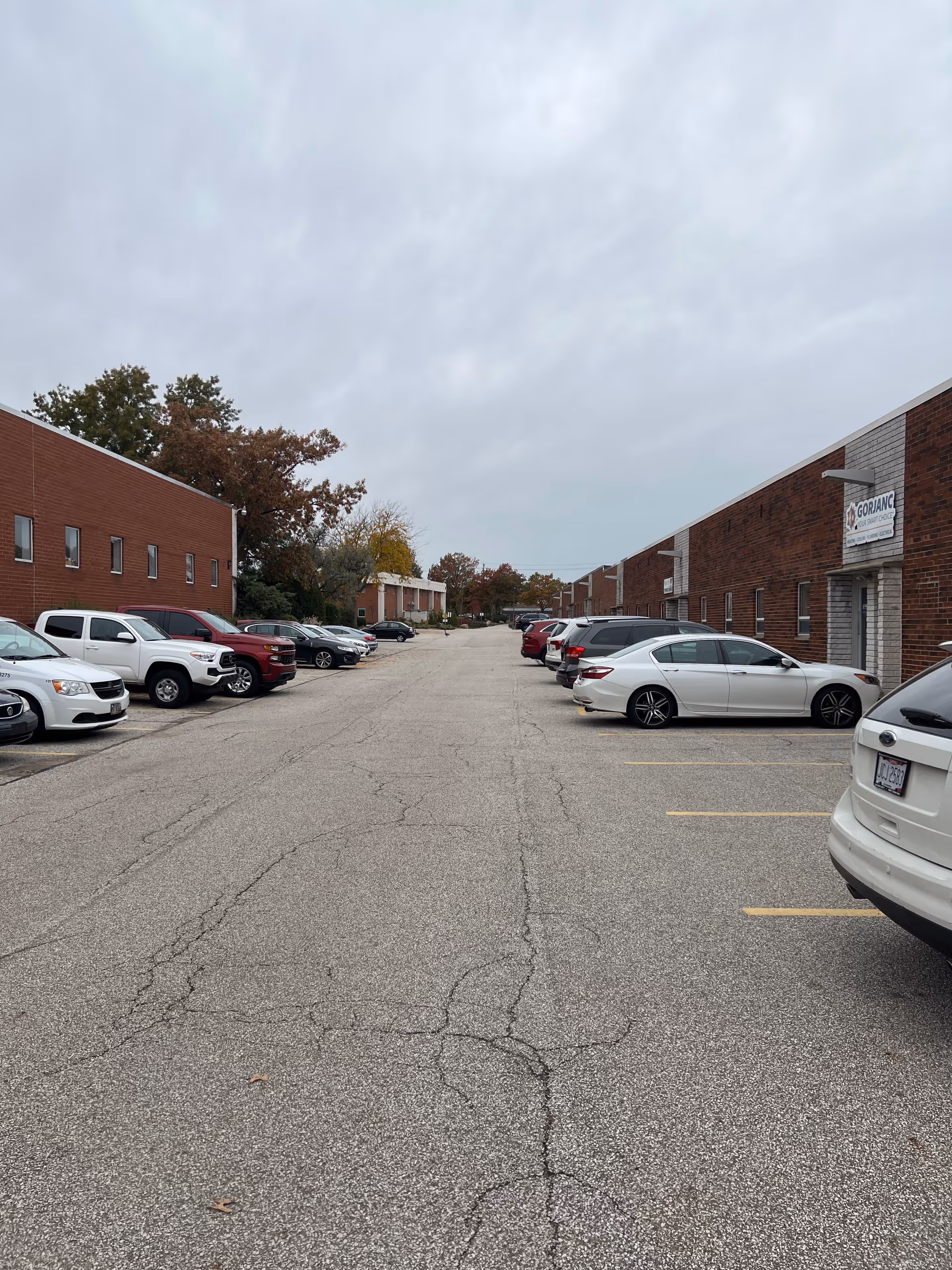 Long outdoor parking lot between brick buildings of Lizzie’s House Senior Home Care.