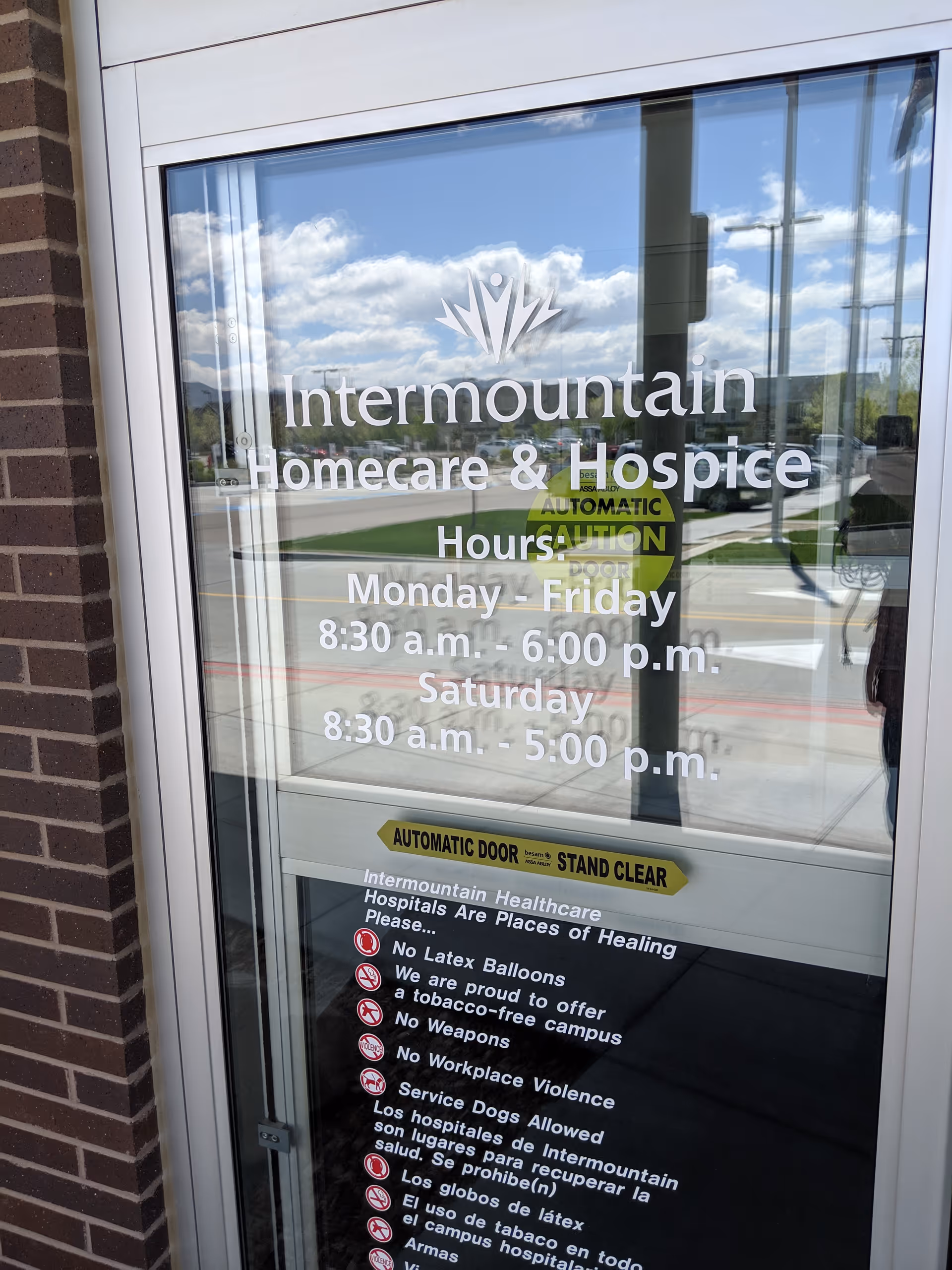 Glass entrance door displays Intermountain Homecare and Hospice branding and operating hours.