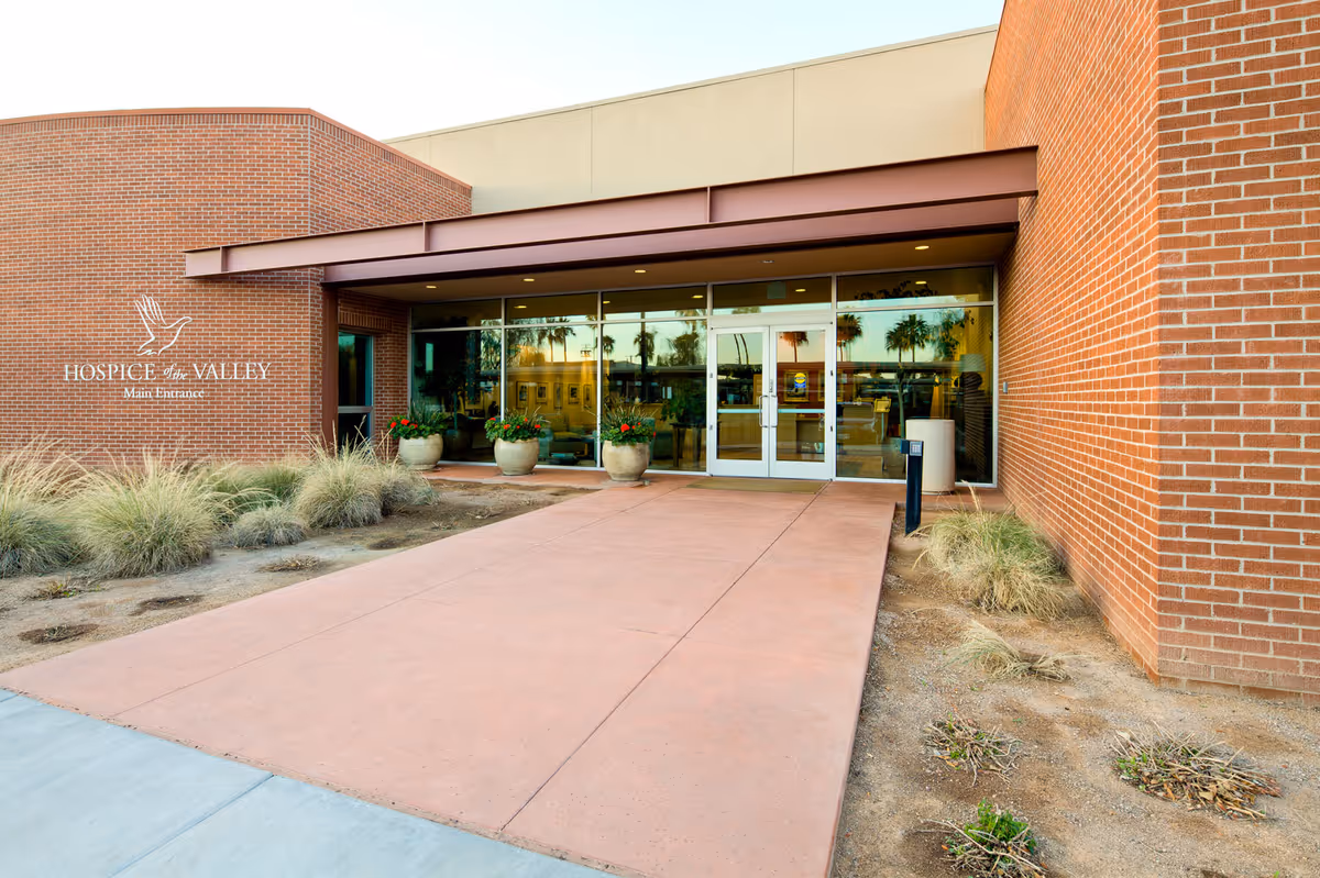 Exterior view of Hospice of the Valley entrance with brick facade and glass doors.