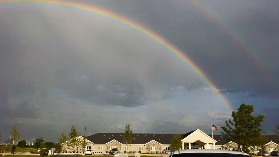 Front exterior of Villas of Holly Brook Assisted Living in Washington, IL with a rainbow.