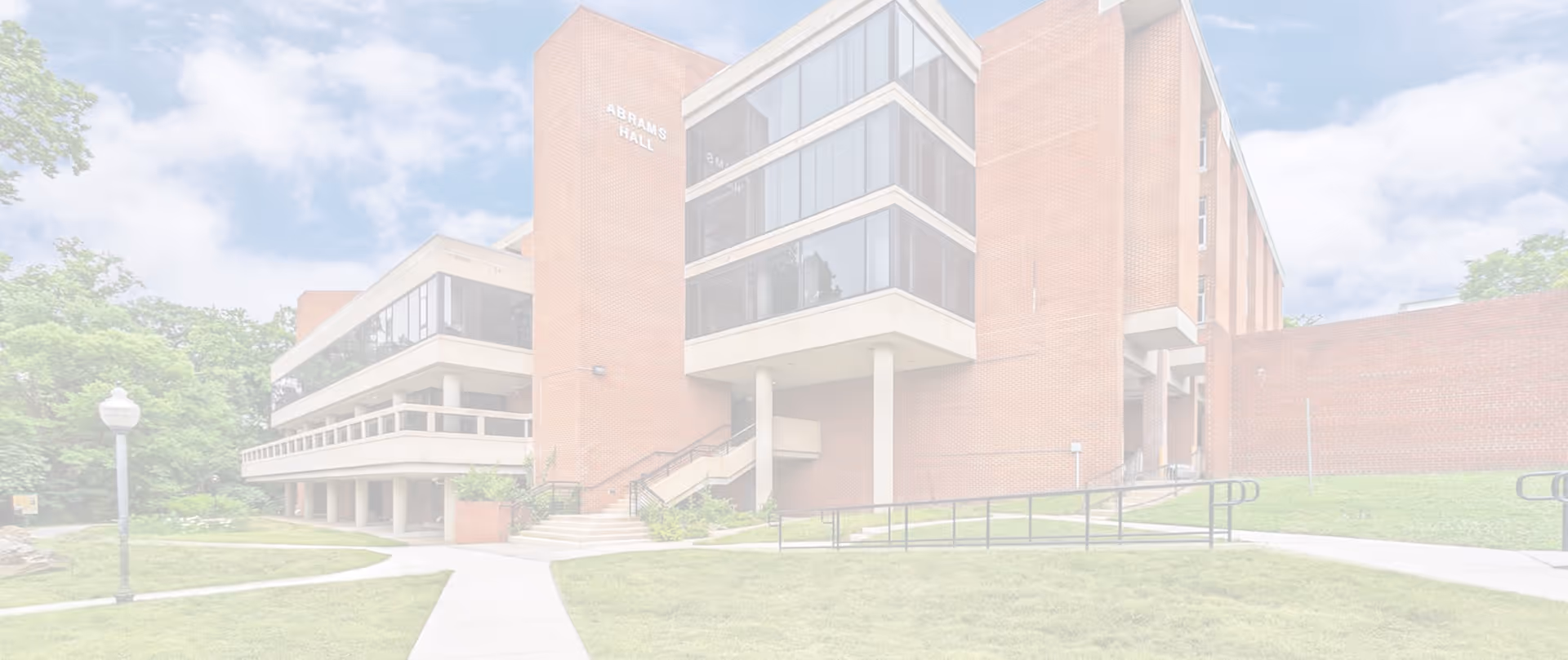 Exterior view of Abrams Hall Senior Apartments building with brick facade and entrance stairs.