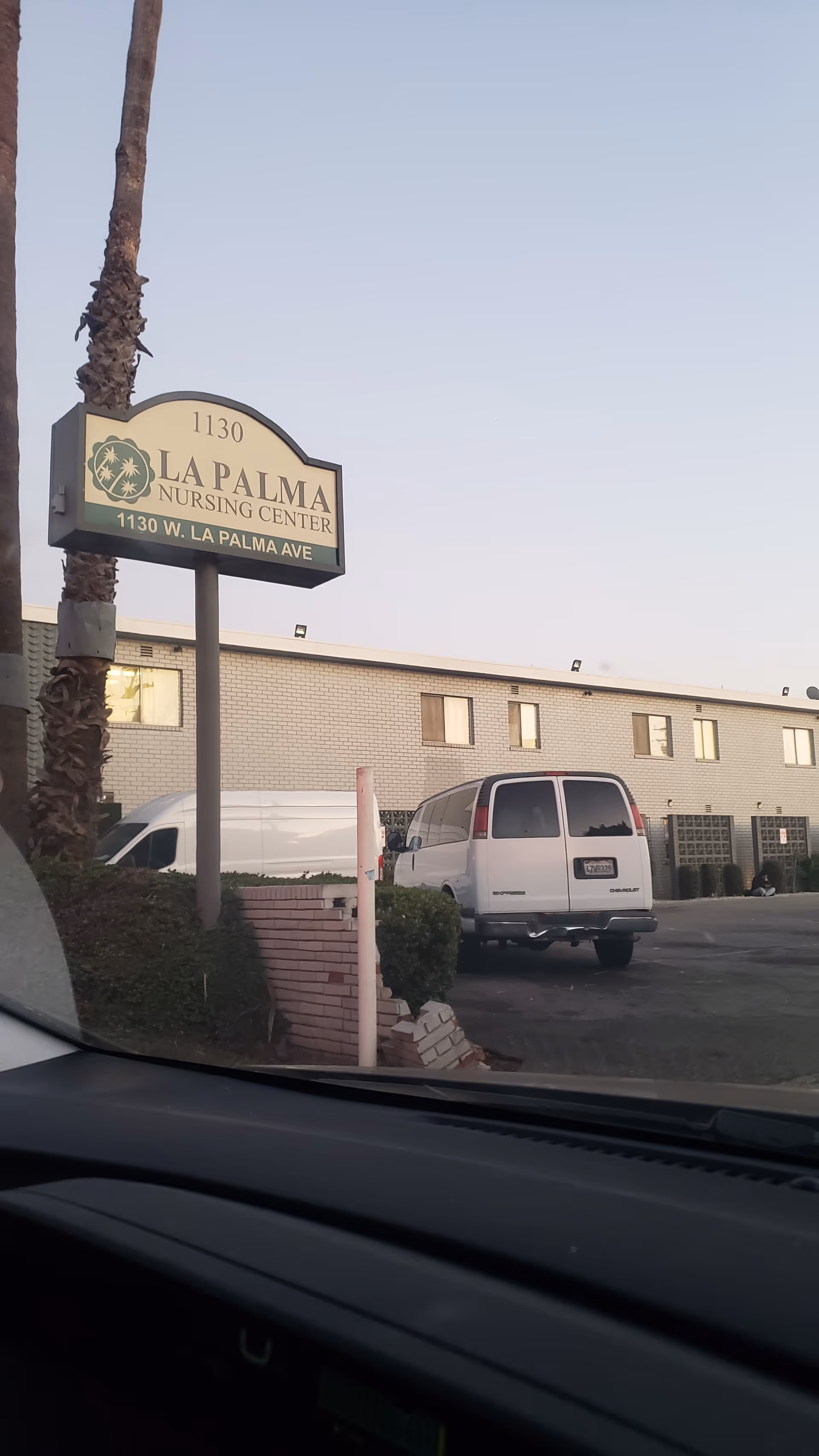 La Palma Nursing Center sign and a single-story building exterior with a white van parked nearby.