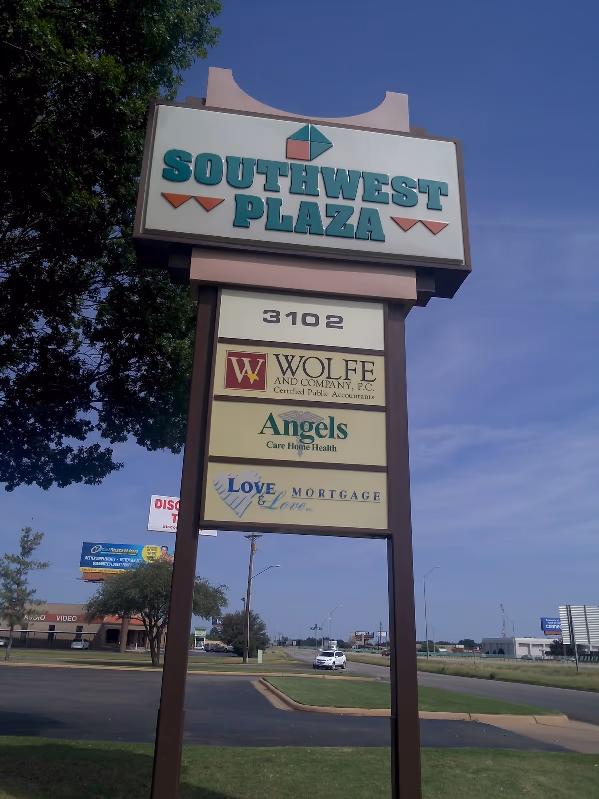 Tall outdoor plaza sign displaying tenants, including Angels Care Home Health, at Southwest Plaza.