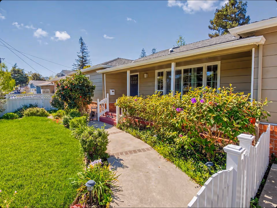 Front yard and porch of a single-story senior care home with a lush garden.
