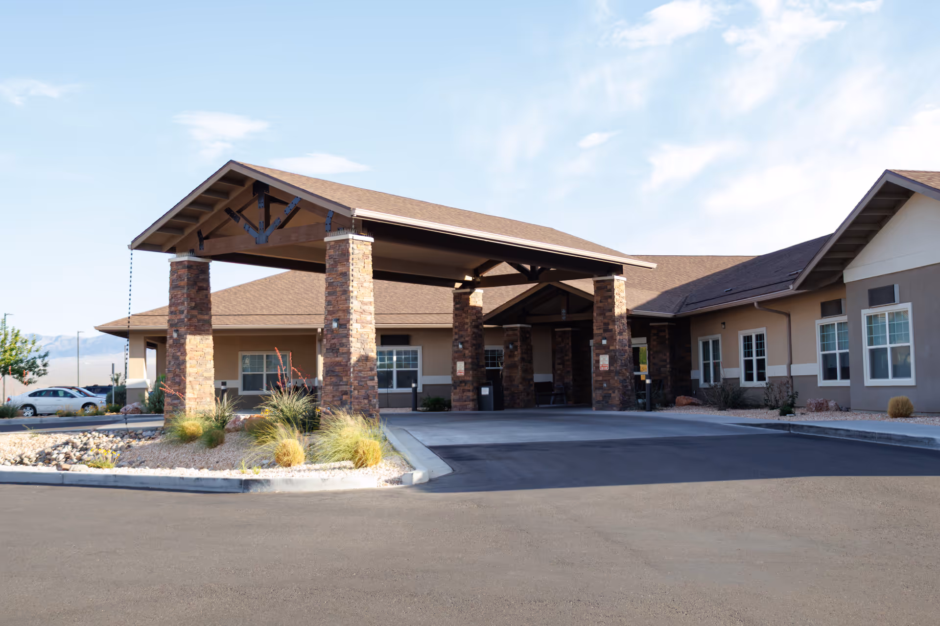 Exterior view of Mesa Valley Estates entrance with stone pillars and a covered driveway.