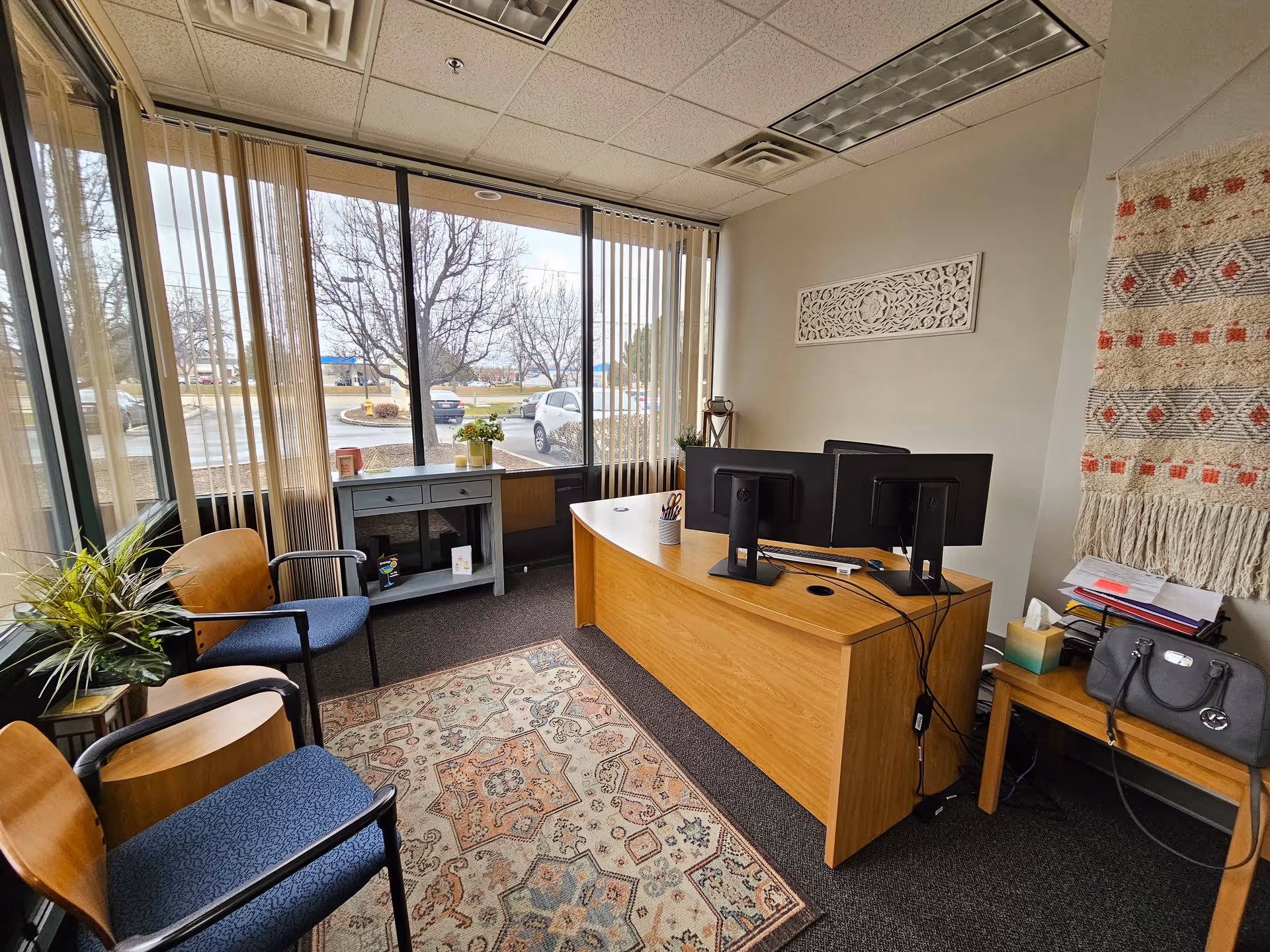 Reception area of a senior facility with desk, computers, chairs, and large windows.