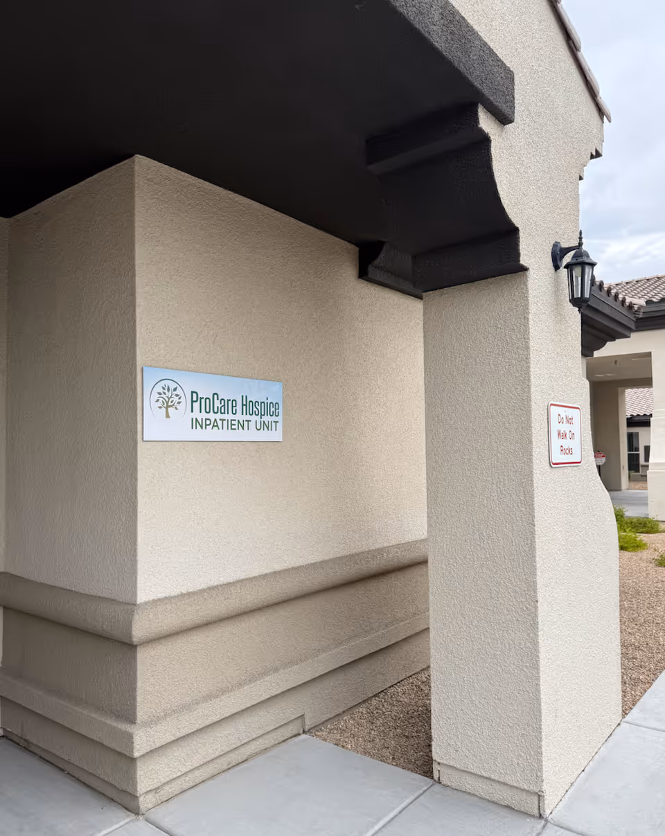 Exterior view of a beige building with a ProCare Hospice Inpatient Unit sign.