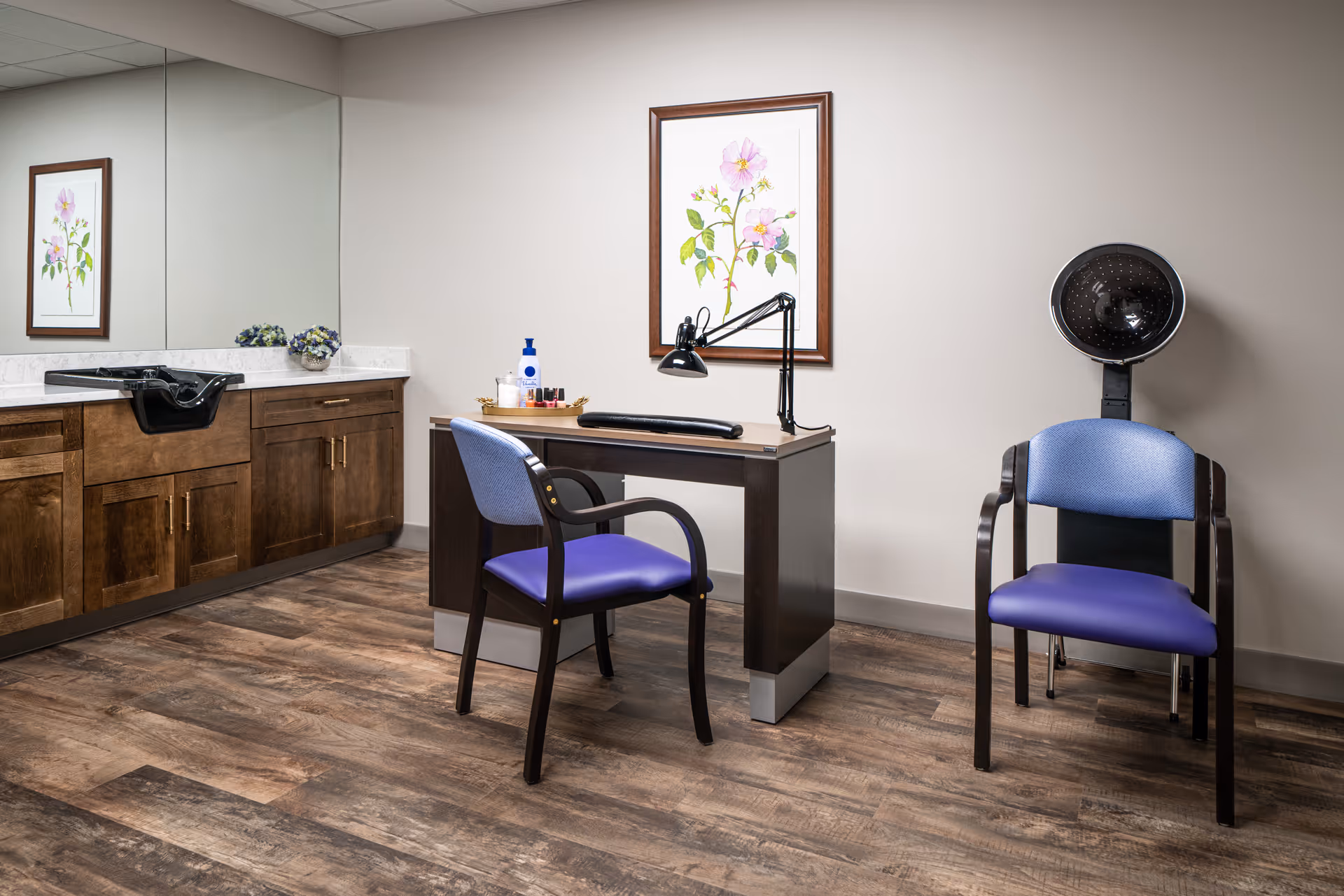 Interior view of a senior facility salon with sink, desk, artwork, and purple chairs.
