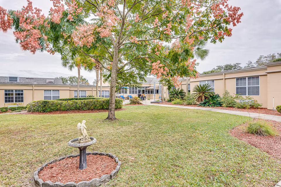 Exterior view of B & Y Care Home courtyard with fountain and landscaping.