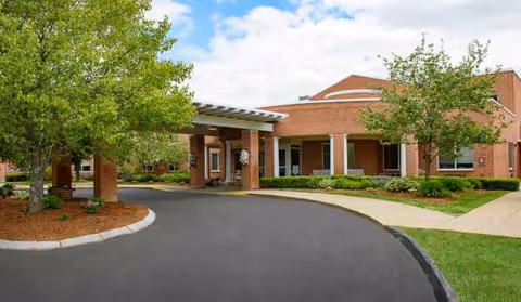 Exterior front entrance of Life Care Center of West Bridgewater with trees and a circular driveway.