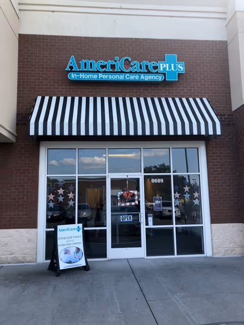 Front view of AmeriCare Plus storefront with striped awning and glass entry doors.