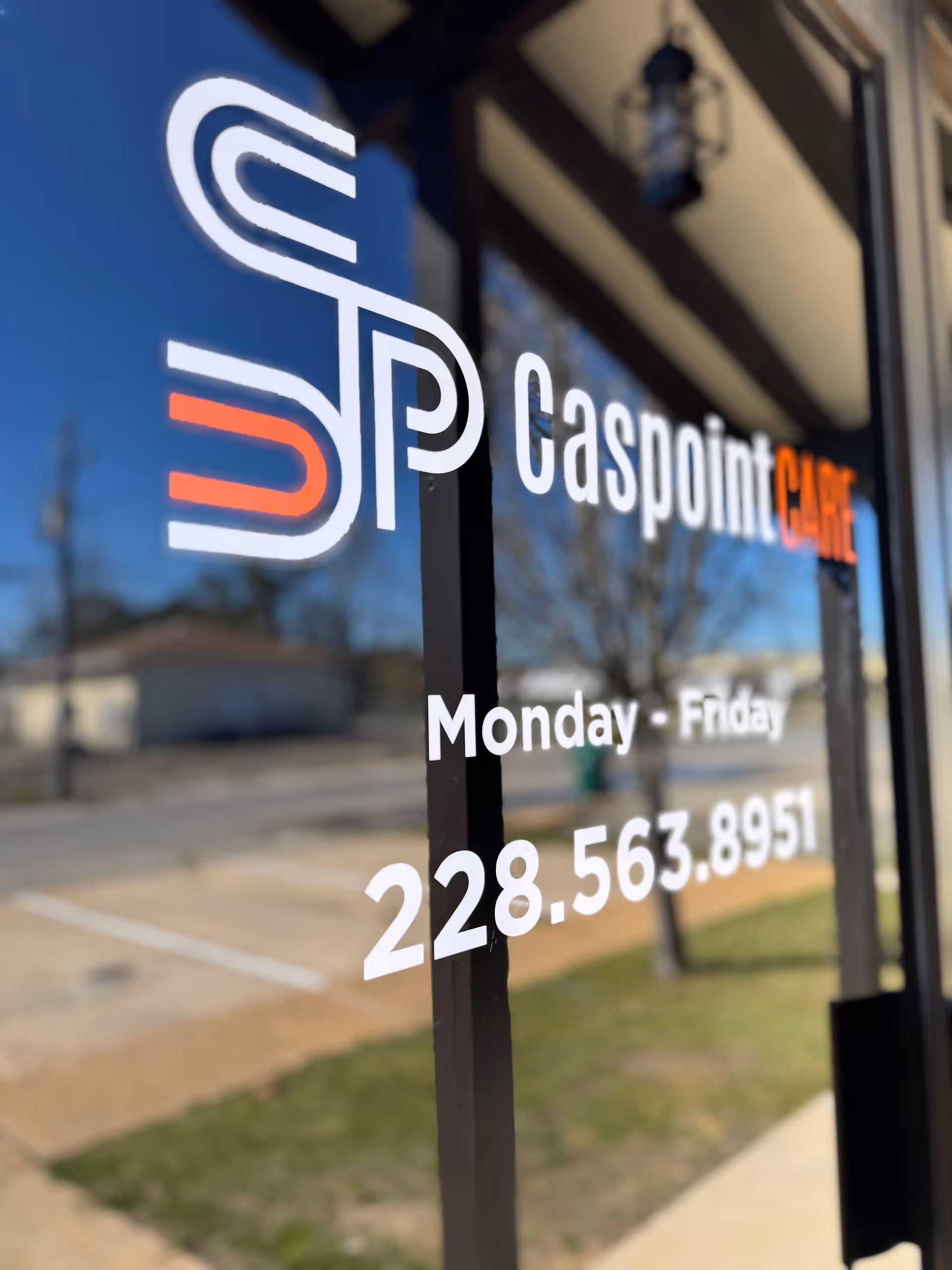 Caspoint Care Inc. logo on glass entry door with street reflection.