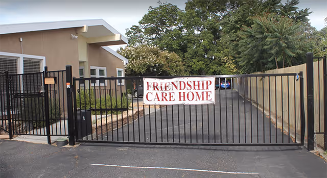 Exterior of Friendship Care Home with a gated entrance and driveway.