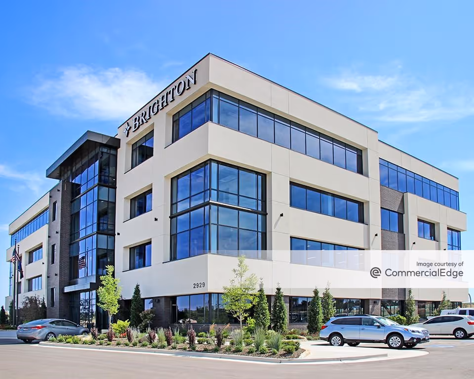 Modern multi-story building with large glass windows and landscaped front entrance in Boise