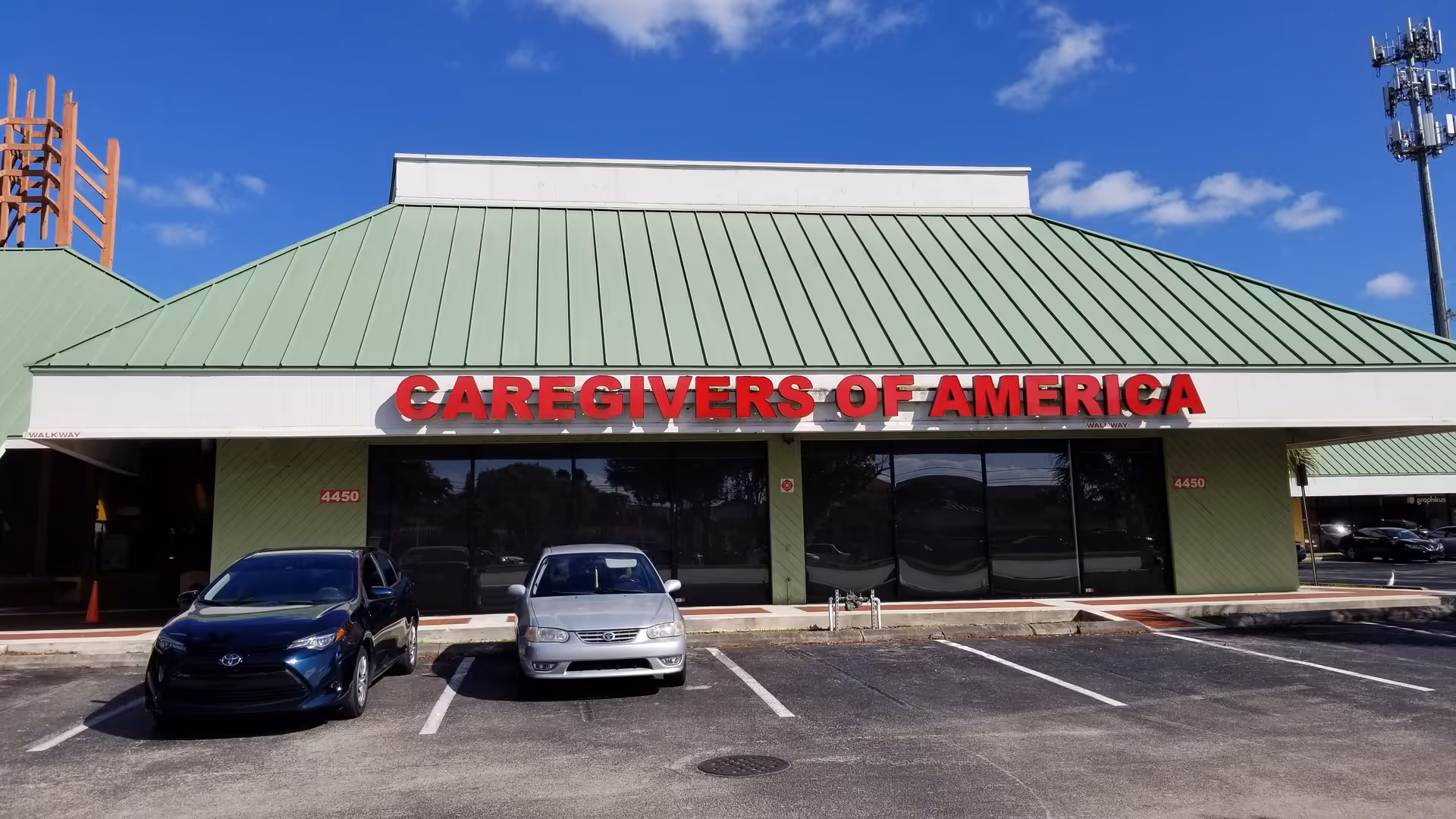 Front view of CareGivers of America facility with green roof and parked cars.