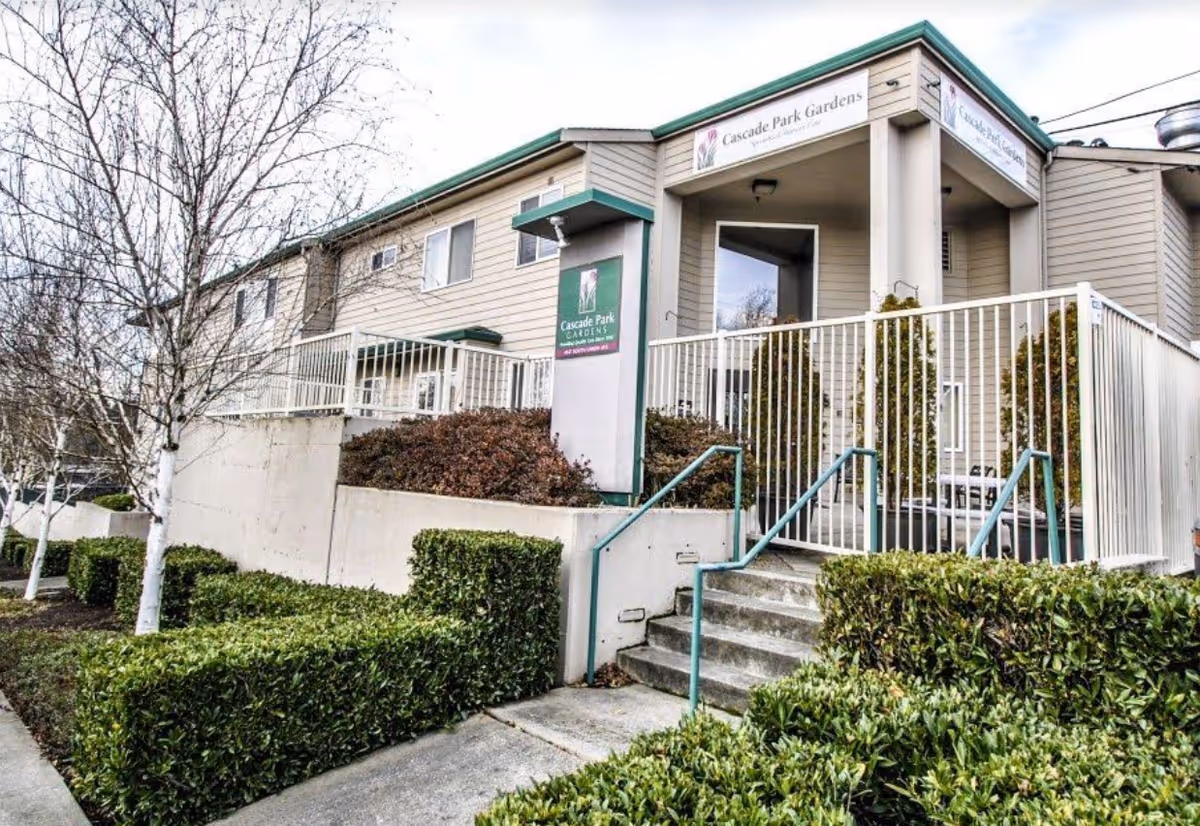 Exterior view of Cascade Park Gardens with entrance stairs and trimmed hedges.