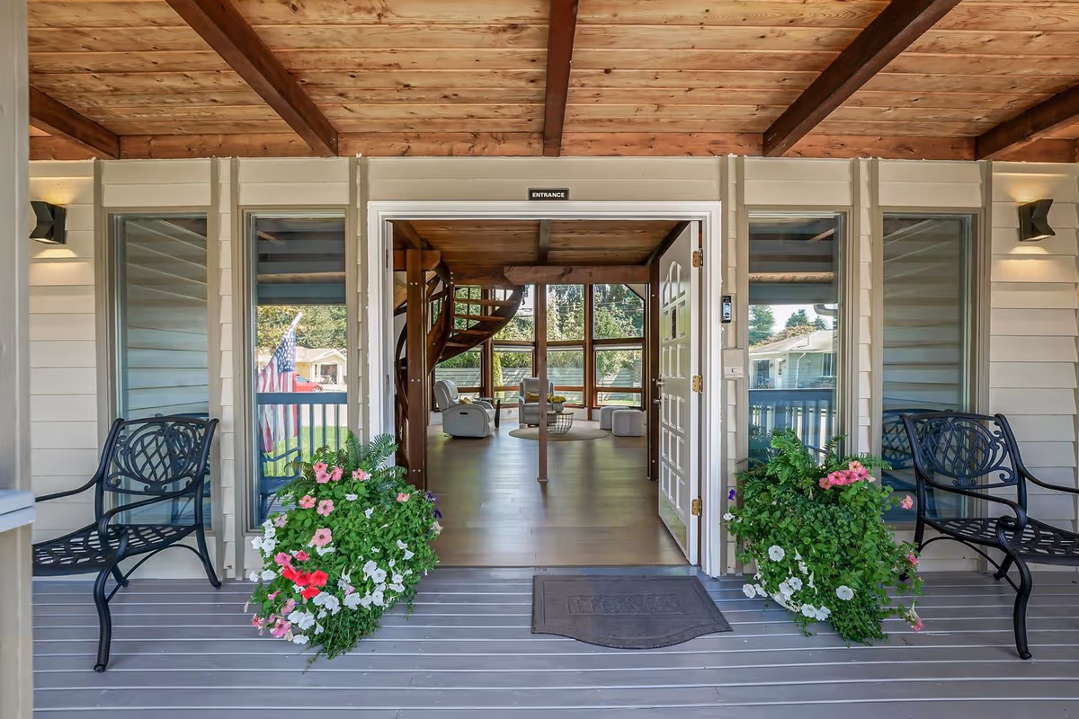 Open front entrance with benches, flower planters, and interior seating visible through doors.