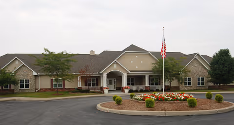 Brookdale Clinton exterior with circular driveway, flagpole, and manicured front entrance.