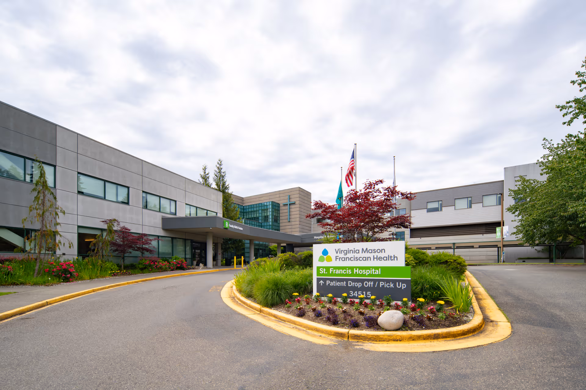Exterior view of St. Francis Hospital entrance with sign and landscaped circle.