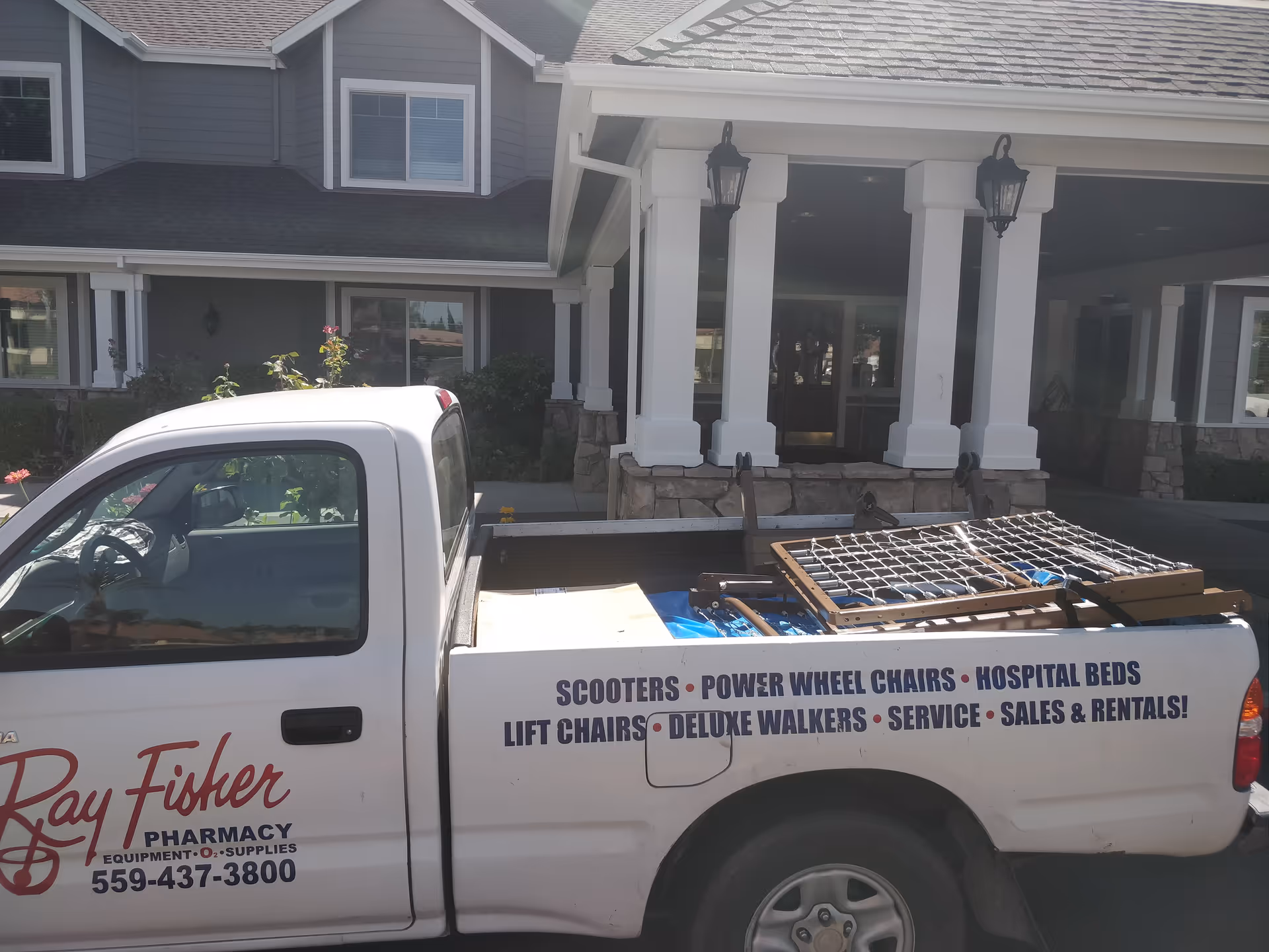 Front entrance of The Grove Senior Living facility with a white pickup truck parked outside.