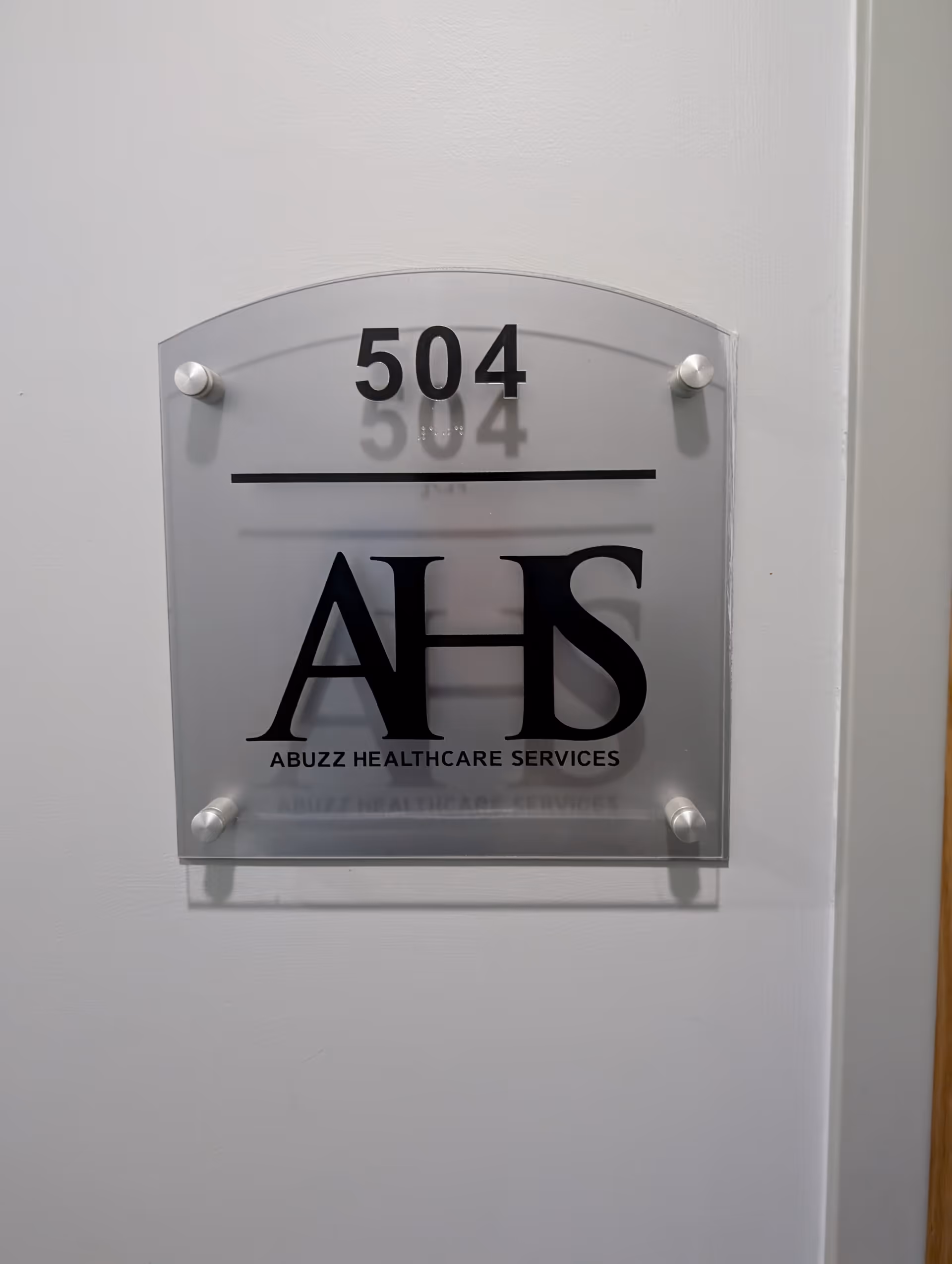 Frosted glass wall plaque showing room 504 and the AHS logo