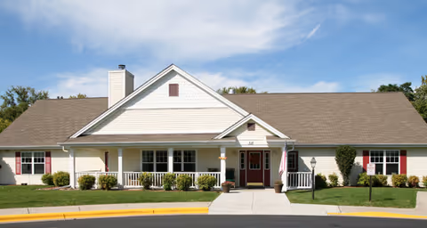 Exterior view of Sterling House of Monroe with a front porch and red doors.