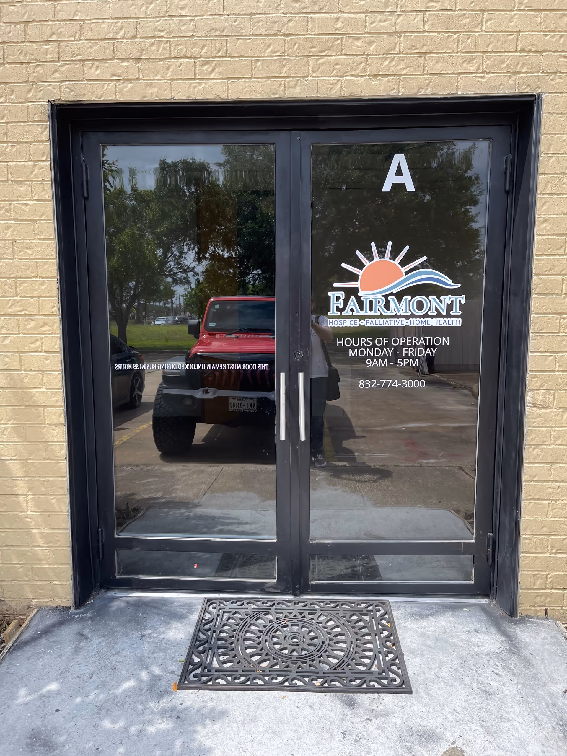 Front entrance doors with Fairmont logo; brick exterior and decorative mat.
