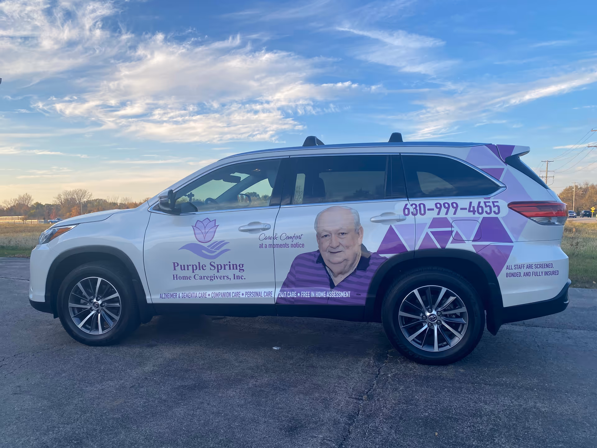 White promotional van for Purple Spring Home Caregivers with logo and portrait.