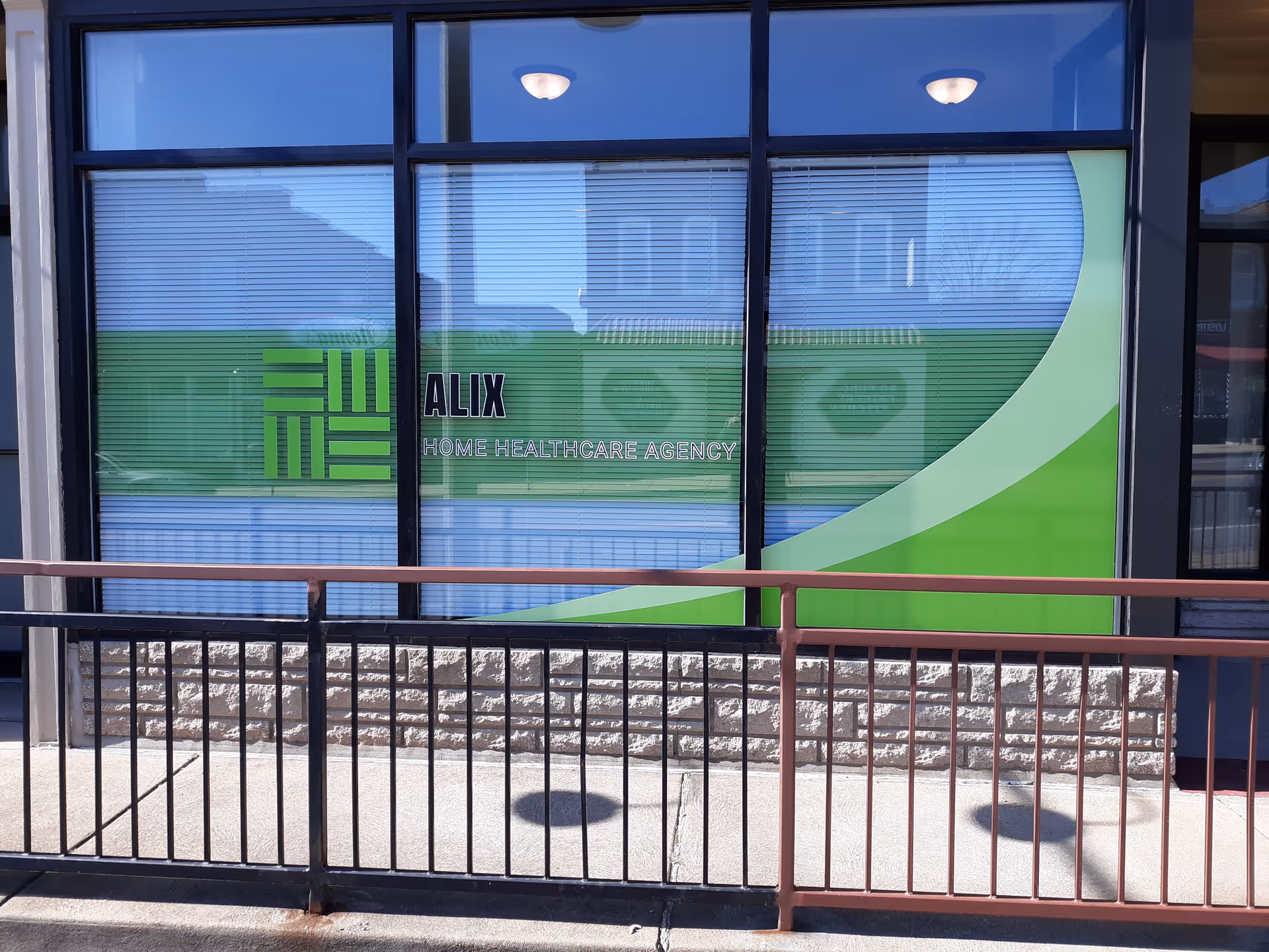 Front exterior of Alix Home Health Care Agency with green signage on window.