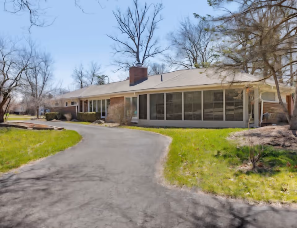 Single-story senior living facility with large windows along a curved driveway.