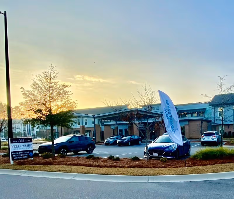 Exterior view of The Marsh at Carolina Park with a banner and parked cars.
