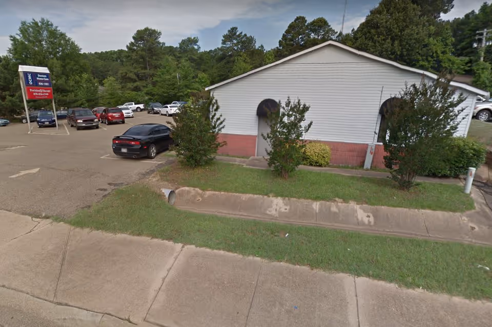 Exterior view of Doctor's Home Care facility with parking lot and greenery.