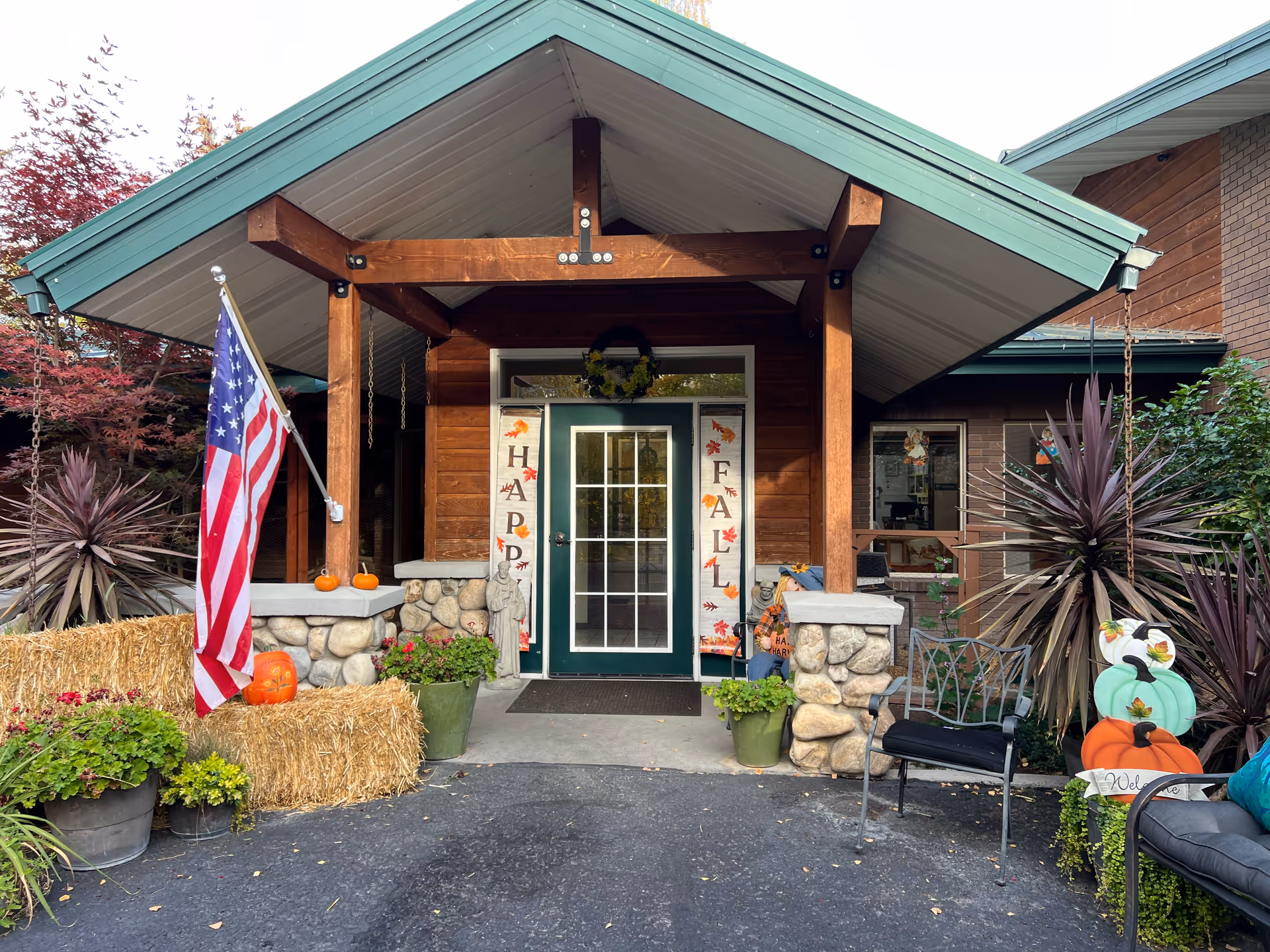 Front entrance of Creekside Residential Care Center with fall decor, pumpkins, and an American flag.