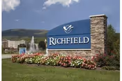 Blue Richfield sign with fountain and colorful flowers in a landscaped front area.