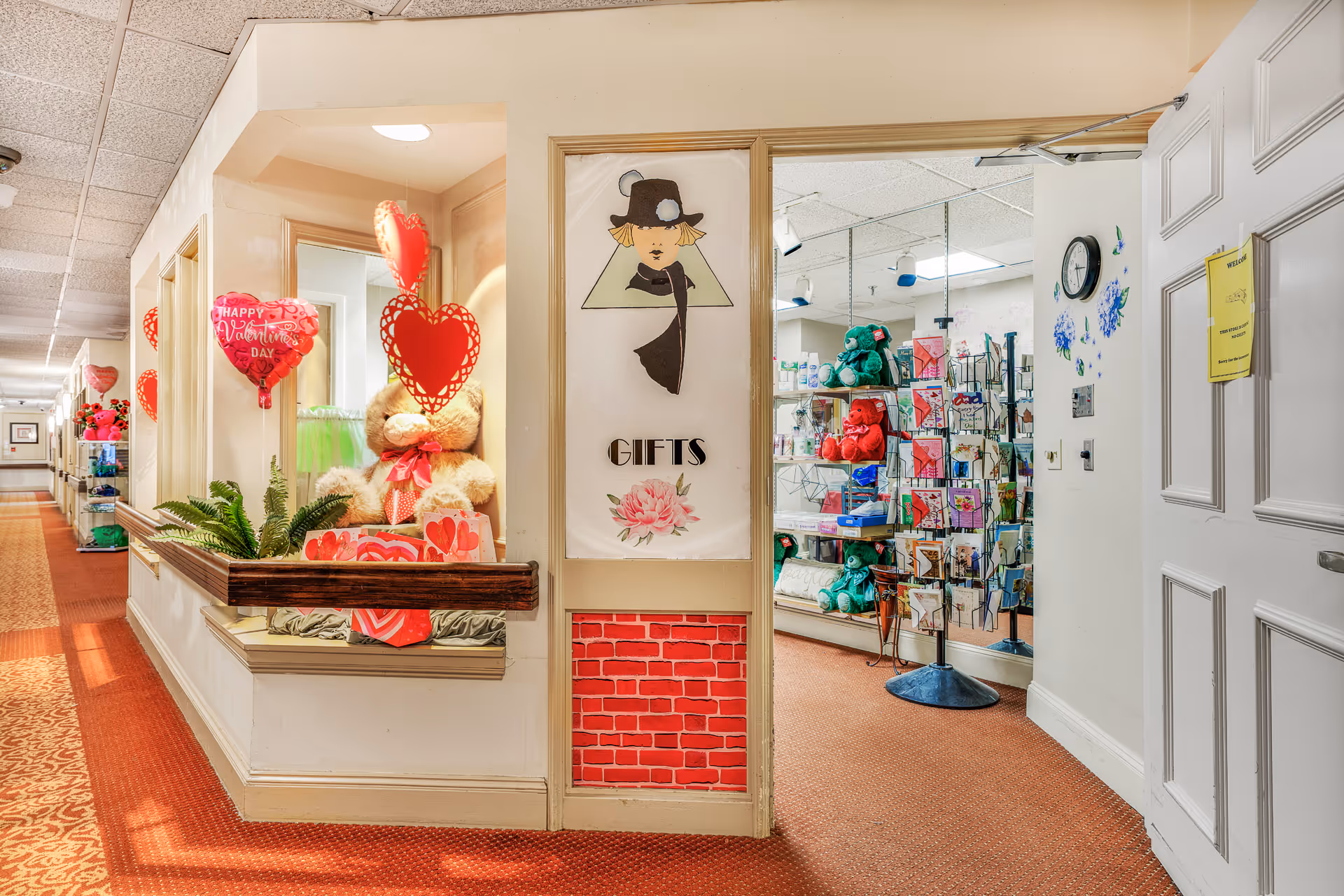 Hallway of a senior living facility with a gift shop display and heart decorations.