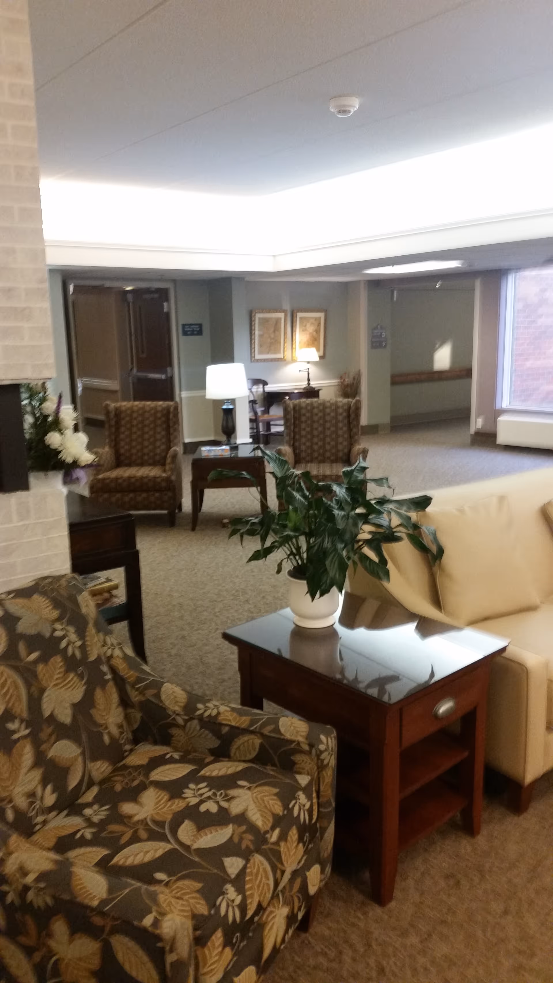 Interior lounge at Covenant Living of Golden Valley with patterned chairs, couches, tables, and plants.