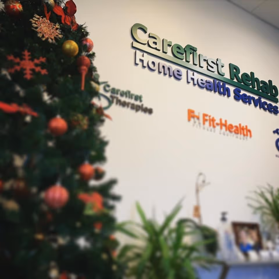 Interior lobby with a Christmas tree and Carefirst Rehab Home Health Services sign on wall.