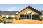 Exterior view of Wood Presbyterian Home with brick front entrance and outdoor seating area.