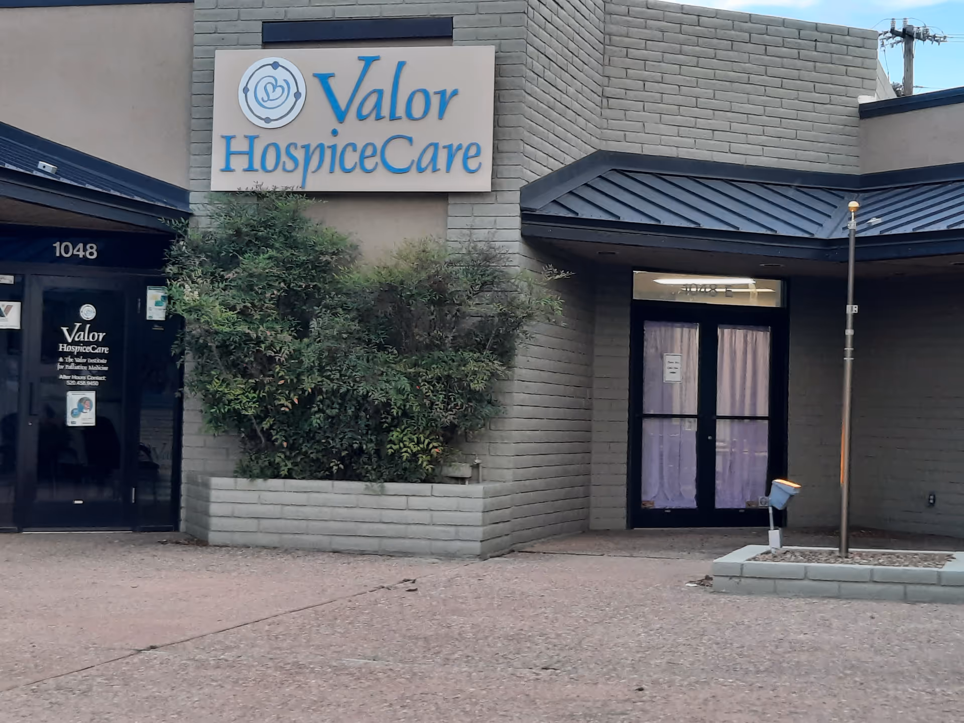 Exterior of Valor HospiceCare building with sign and glass entry doors.