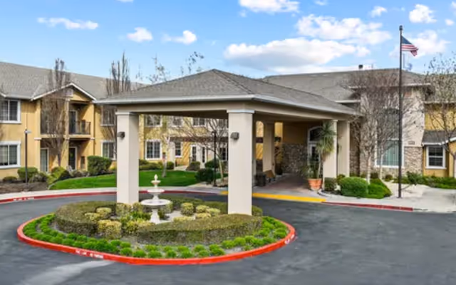 Exterior view of Deering Community Living with porte-cochere, fountain, and manicured landscaping.