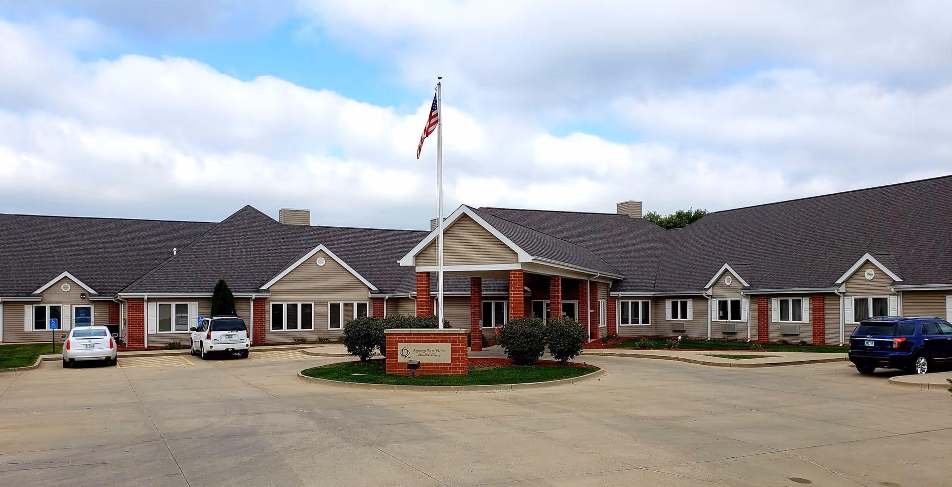Exterior view of Regency Care Center front entrance with flagpole and driveway.