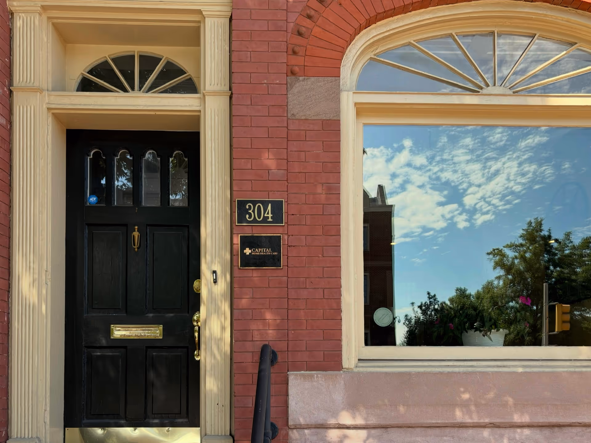 Brick building front with black door, 304 plaque, and arched window.