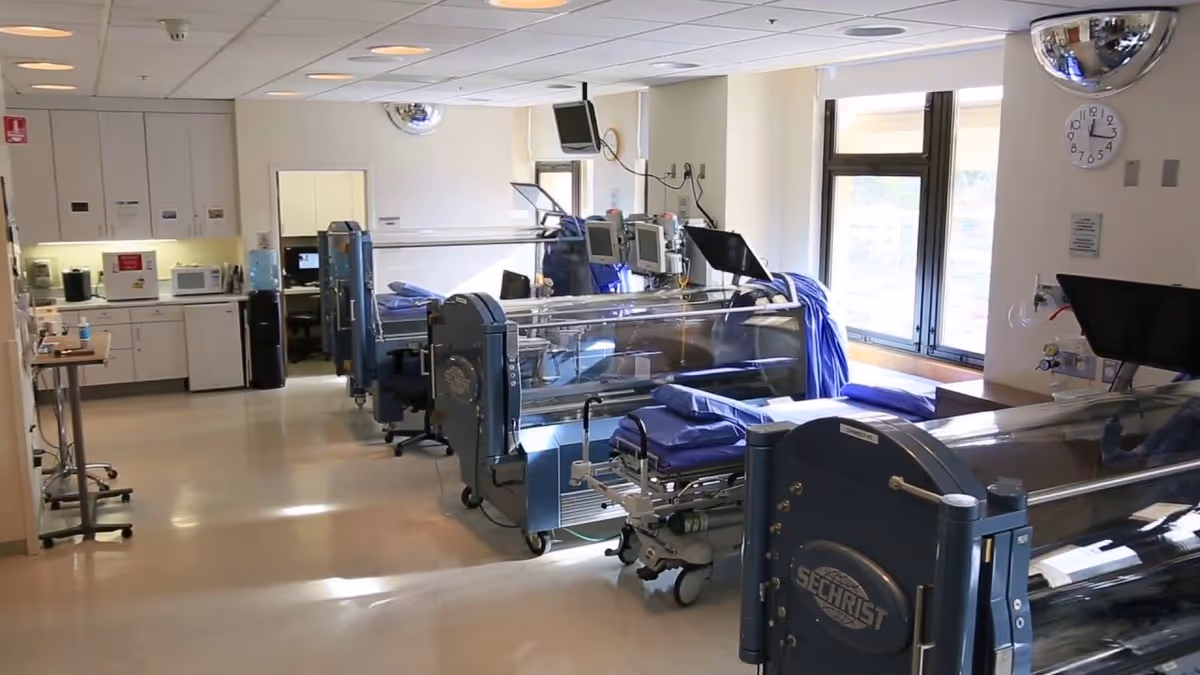 Interior of a medical facility with hyperbaric chambers and monitoring equipment along the walls.