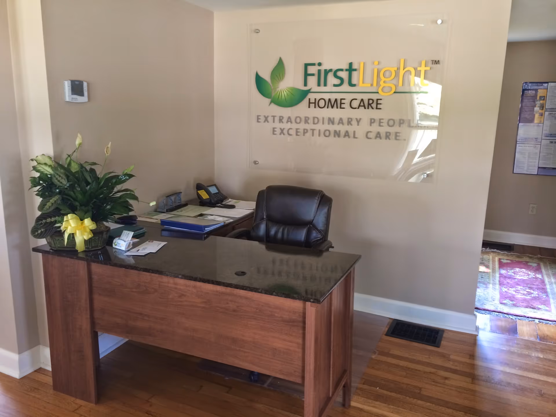 Reception desk in a lobby with a FirstLight Home Care sign on the wall.