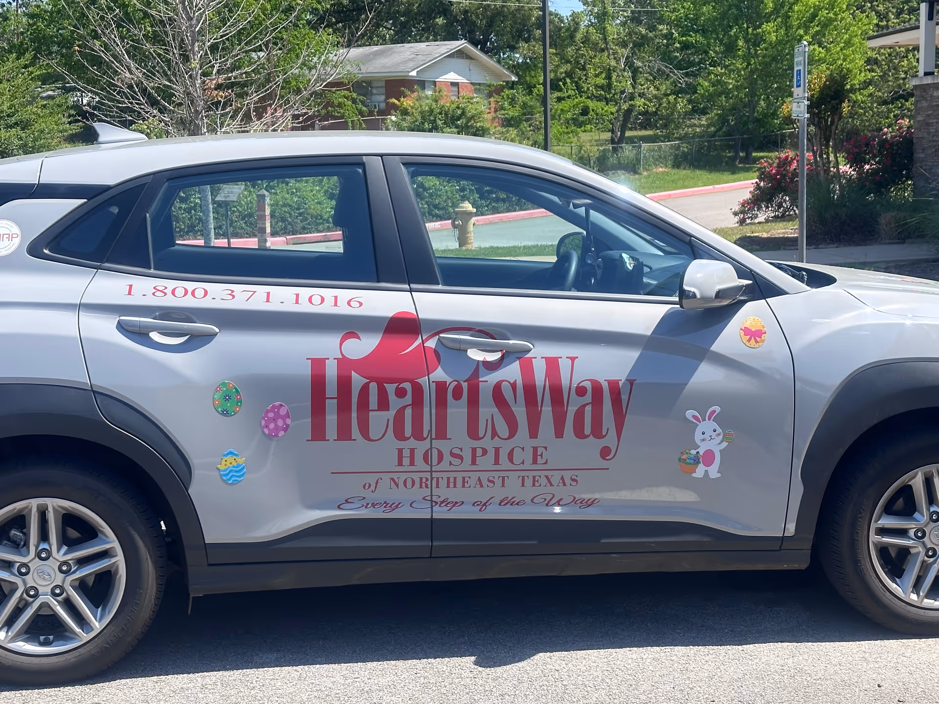 Silver HeartsWay Hospice Longview Office car parked outside with trees and building behind