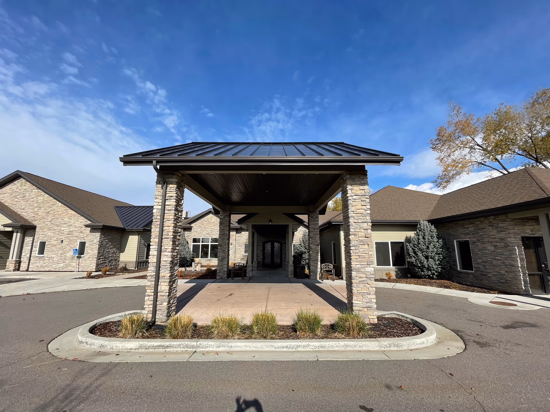 Stone entrance porte-cochere over a driveway at Our House Assisted Living of Ogden.