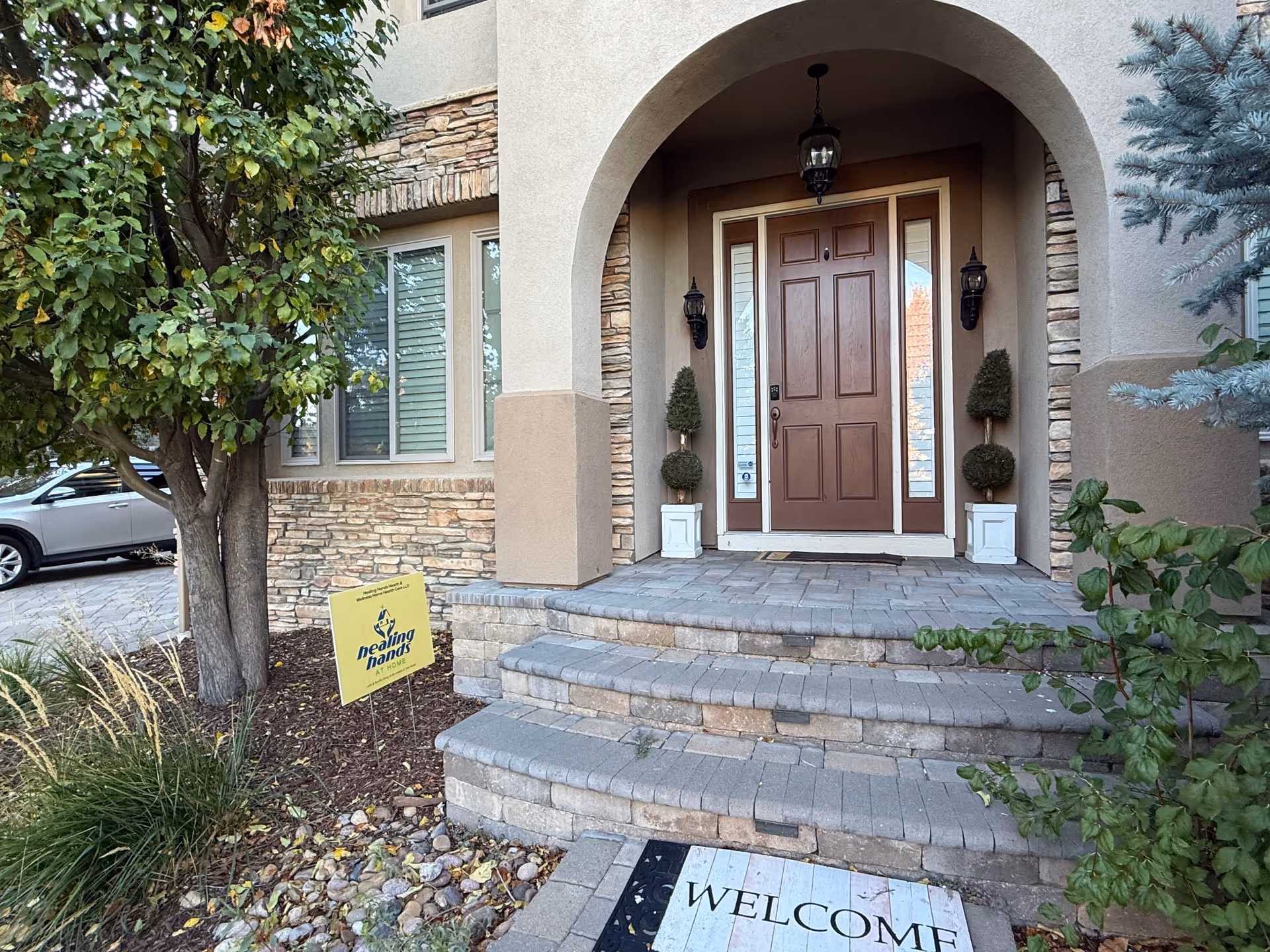 Front entrance of a senior care facility with steps and landscaping.