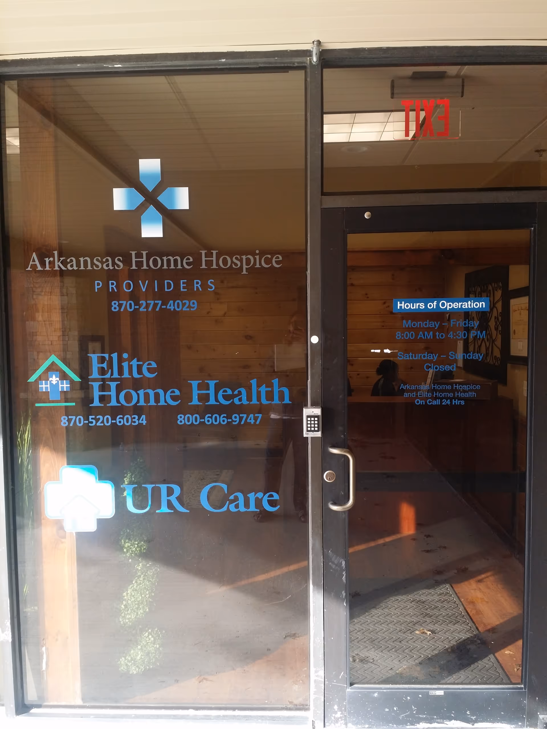 Glass entrance door with Arkansas Home Hospice and Elite Home Health signage.